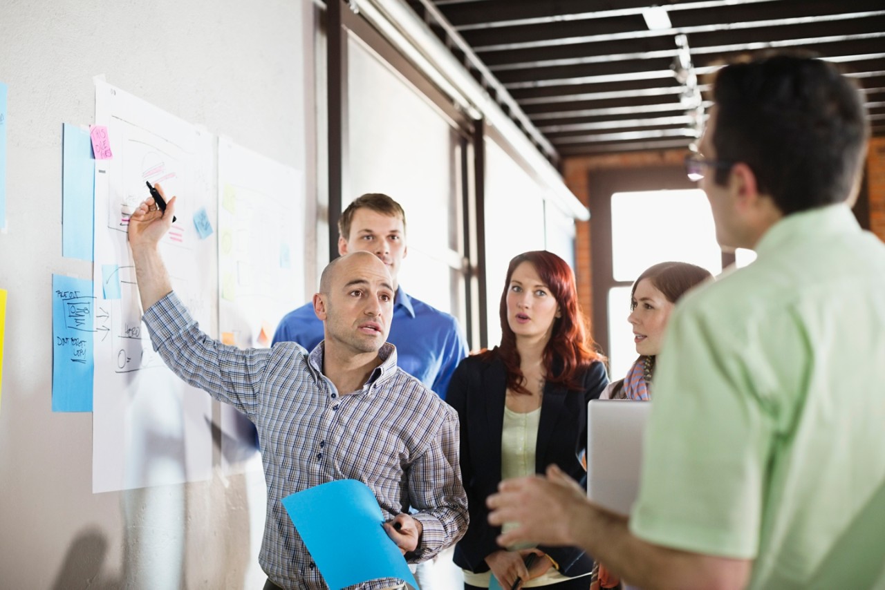 Group of entrepreneurs working on project in creative office space