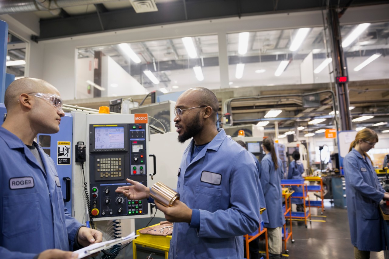 Workers discussing part in textile factory
