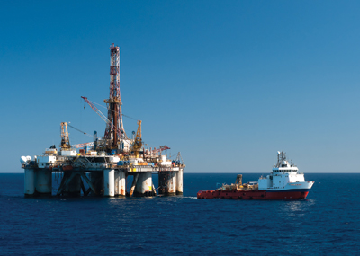 Upstream oil and gas operation with blue sky in ocean with boat