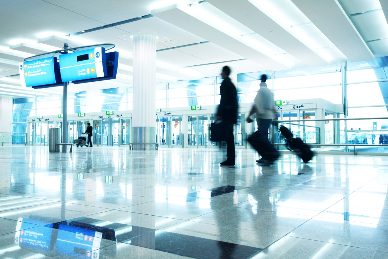 men walking at airport lobby with suitcases; evacuation