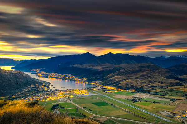 Twilight cityscape surrounded by mountains water